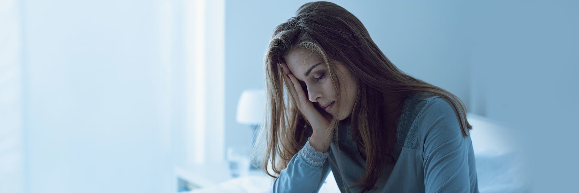 Woman looking tired with hand to face